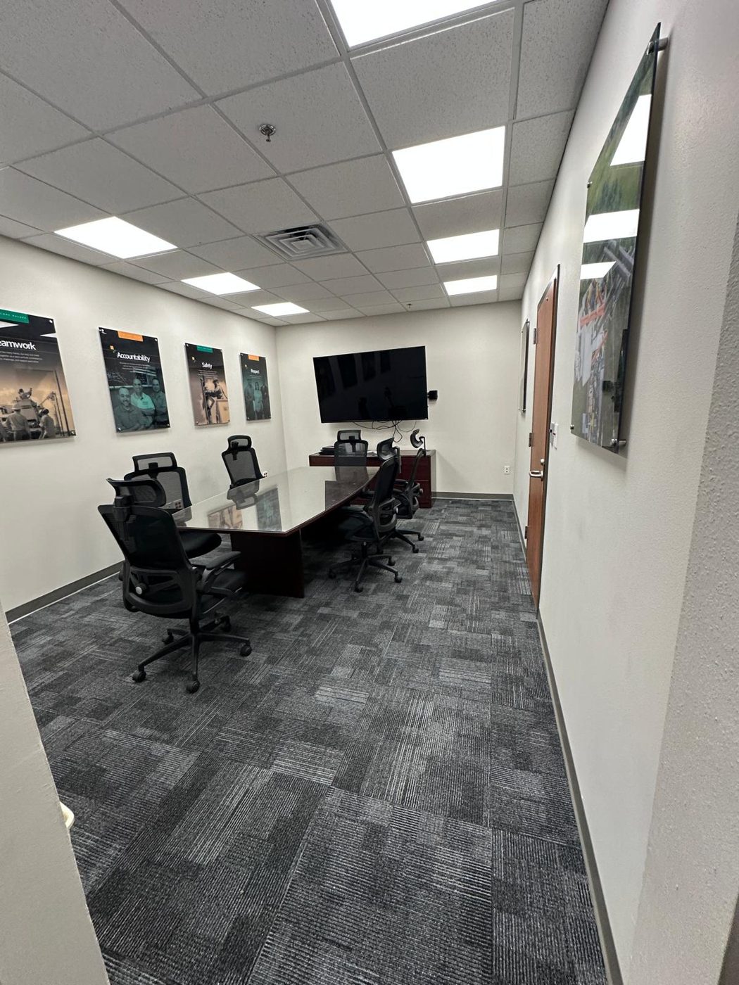 Conference room after remodel with new carpet, lighting, and finishes