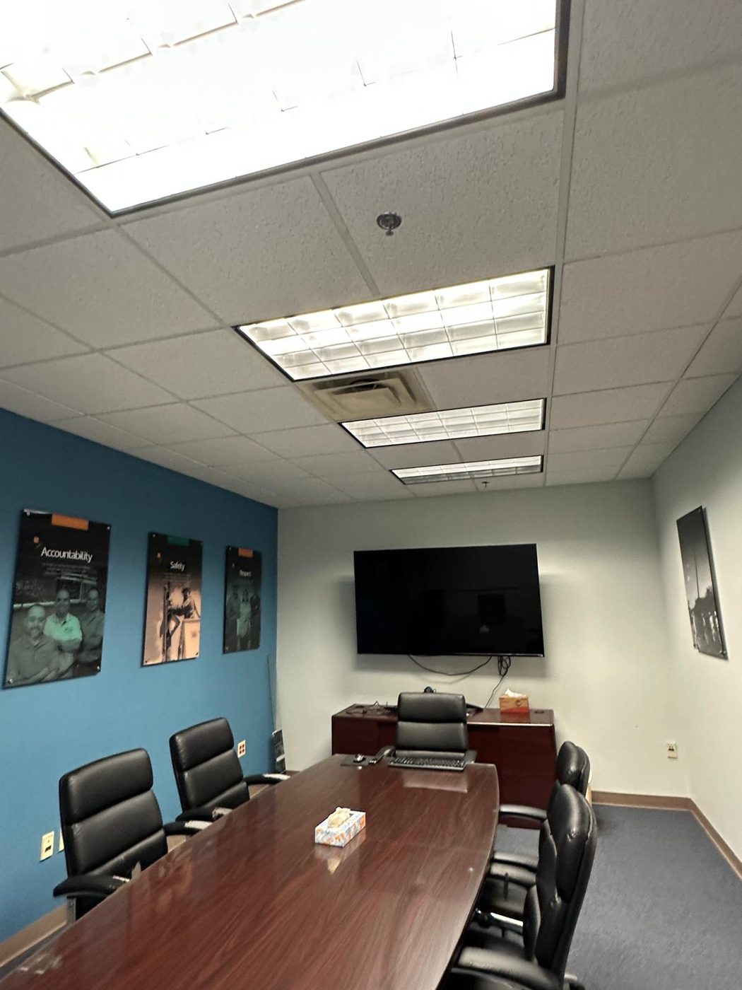 Conference room before remodel with accent wall and older finishes