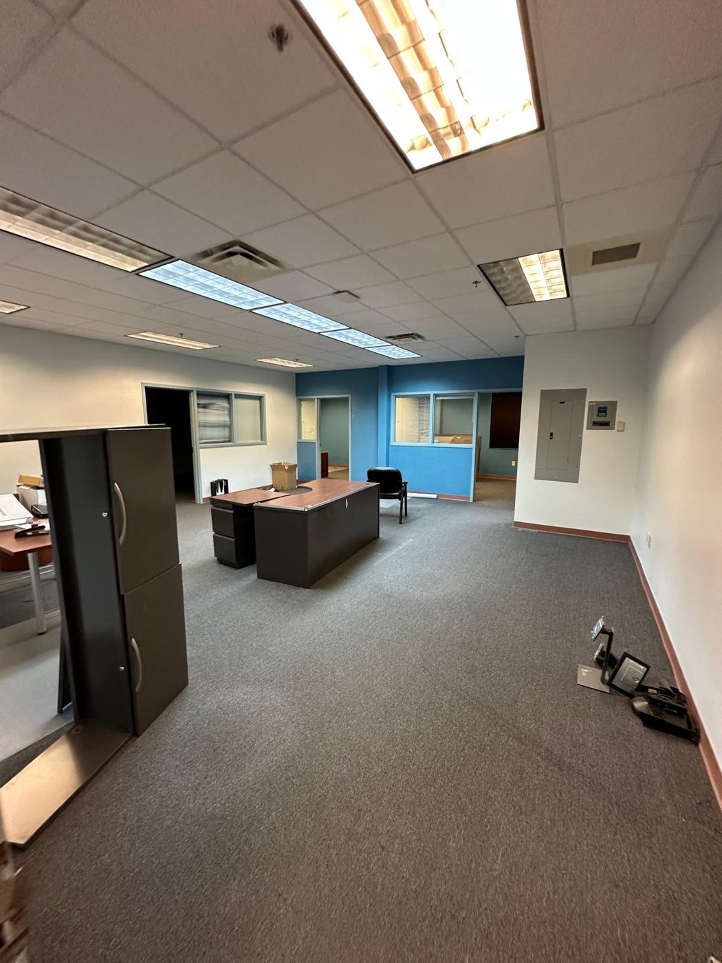 Office before remodel with dated carpet and partition walls